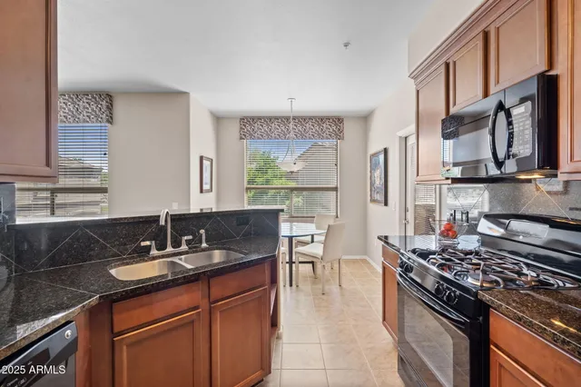 a kitchen with granite countertop a sink stove and cabinets