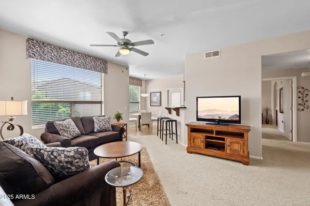 a living room with furniture a chandelier and a flat screen tv