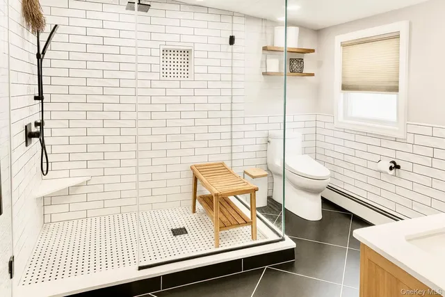 a bathroom with a sink a toilet and shower