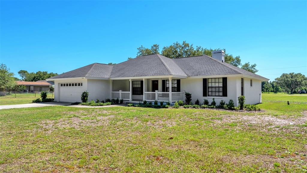 8525 North Campbell Road Lakeland, FL 33810 - Photo 3 of 45 a front view of a house with a garden and porch