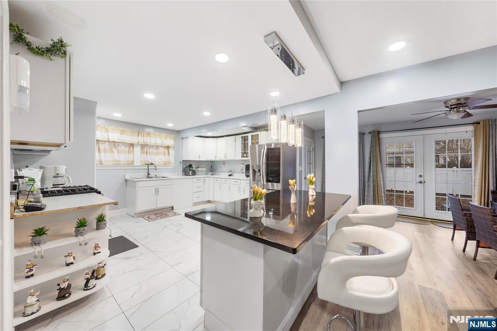 a kitchen with stainless steel appliances kitchen island granite countertop a sink and cabinets