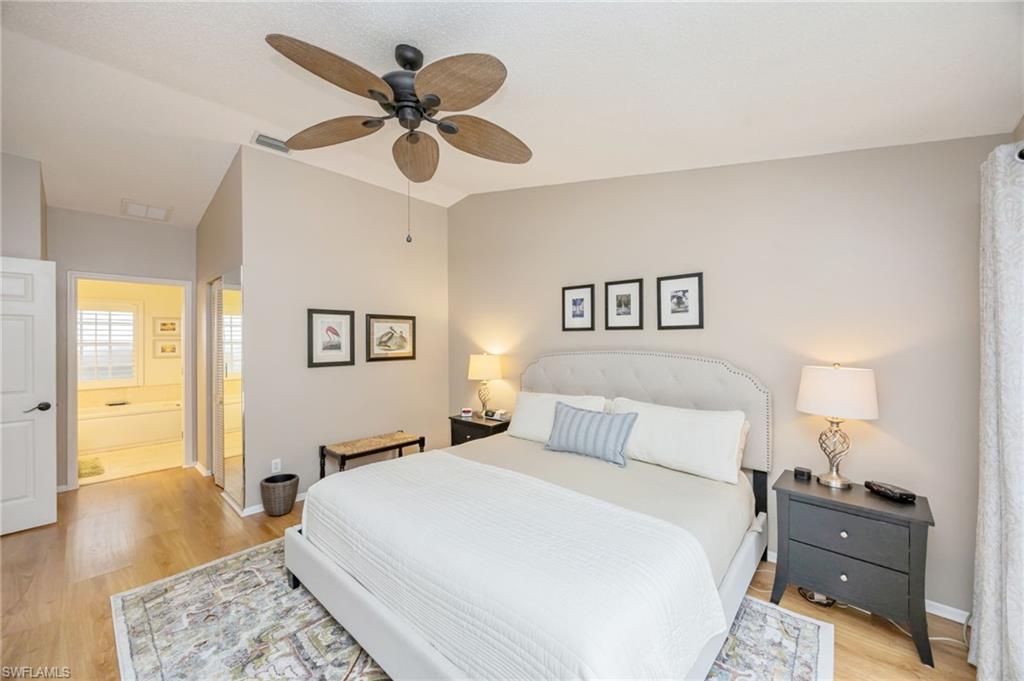 7546 Mill Pond Circle Naples, FL 34109 - Photo 12 of 32 a bedroom with a bed and wooden floor