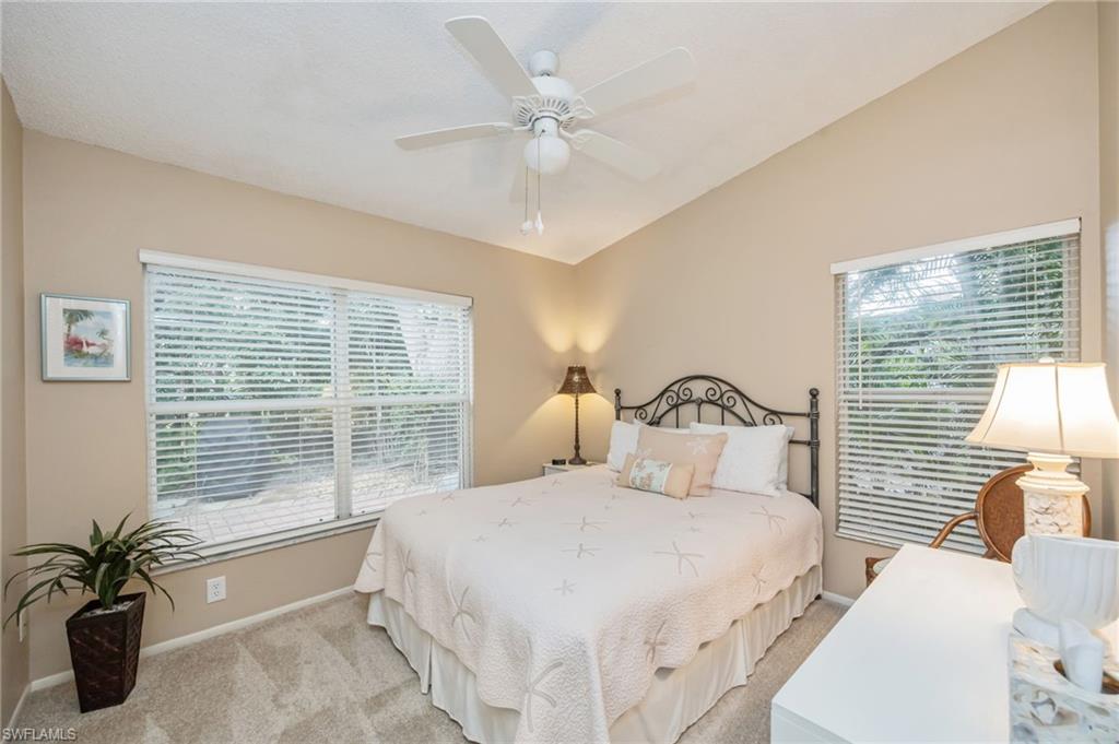 7546 Mill Pond Circle Naples, FL 34109 - Photo 15 of 32 a bedroom with a large bed and a large window