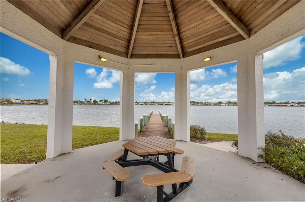 7546 Mill Pond Circle Naples, FL 34109 - Photo 29 of 32 a living room with furniture and a floor to ceiling window