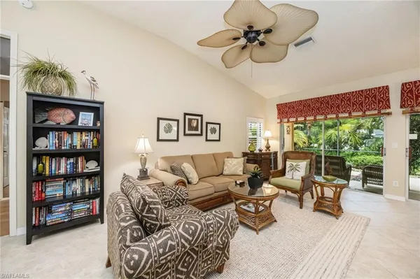 a living room with furniture ceiling fan and a window