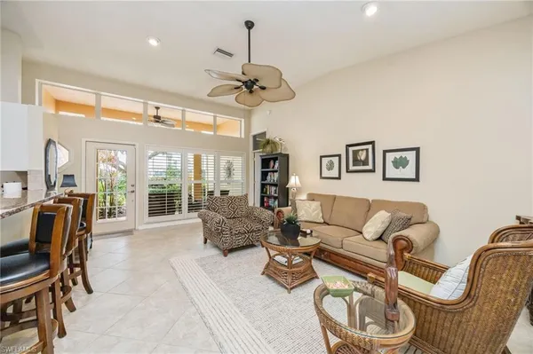a living room with furniture a flat screen tv and a large window