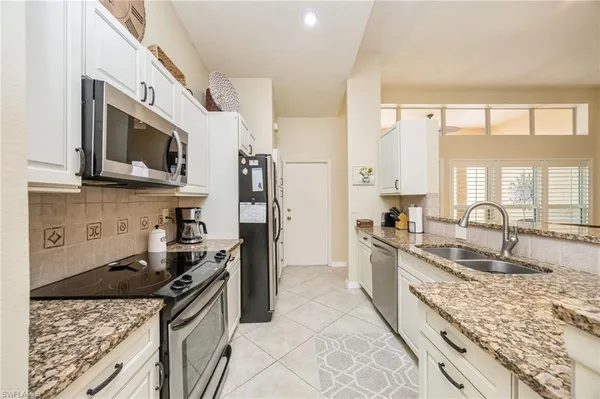 a kitchen with stainless steel appliances granite countertop a stove a sink and a microwave