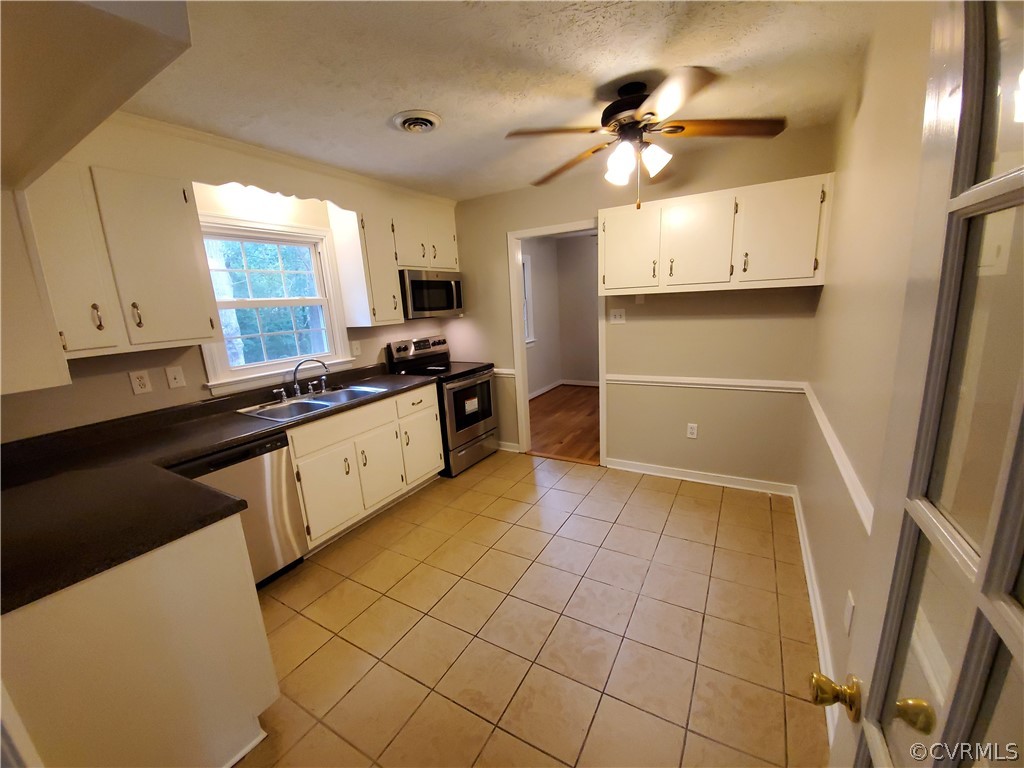 5419 Alberta Road Chesterfield, VA 23832 - Photo 8 of 30 a kitchen with stainless steel appliances a sink a stove a refrigerator cabinets and a window