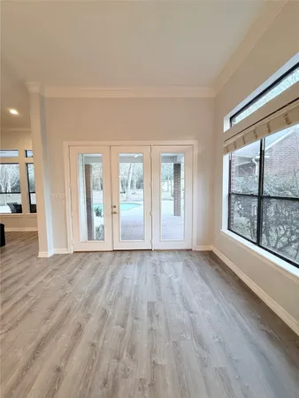 a view of an empty room with a window and wooden floor