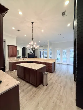 a large kitchen with a large center island and stainless steel appliances