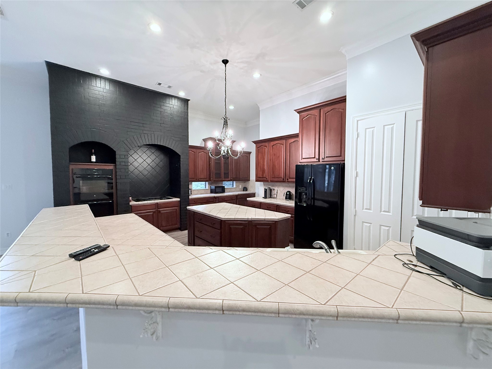 15567 Old Conroe Road Conroe, TX 77384 - Photo 25 of 31 a kitchen with stainless steel appliances kitchen island granite countertop a refrigerator a sink and white cabinets with wooden floor