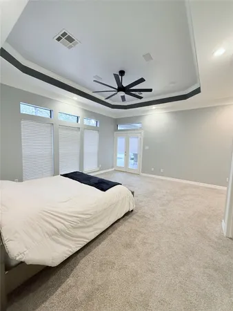 a bedroom with a large bed window and a ceiling fan