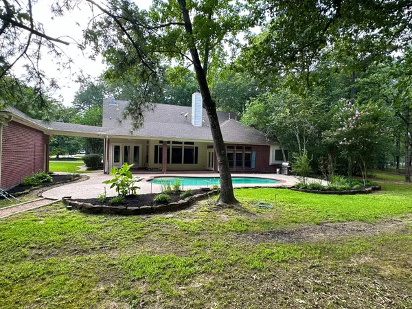 a front view of house with a garden and trees