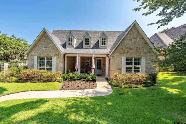 a front view of a house with a yard and fountain