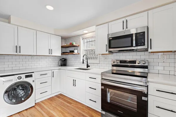 a kitchen with cabinets stainless steel appliances a sink and a counter space