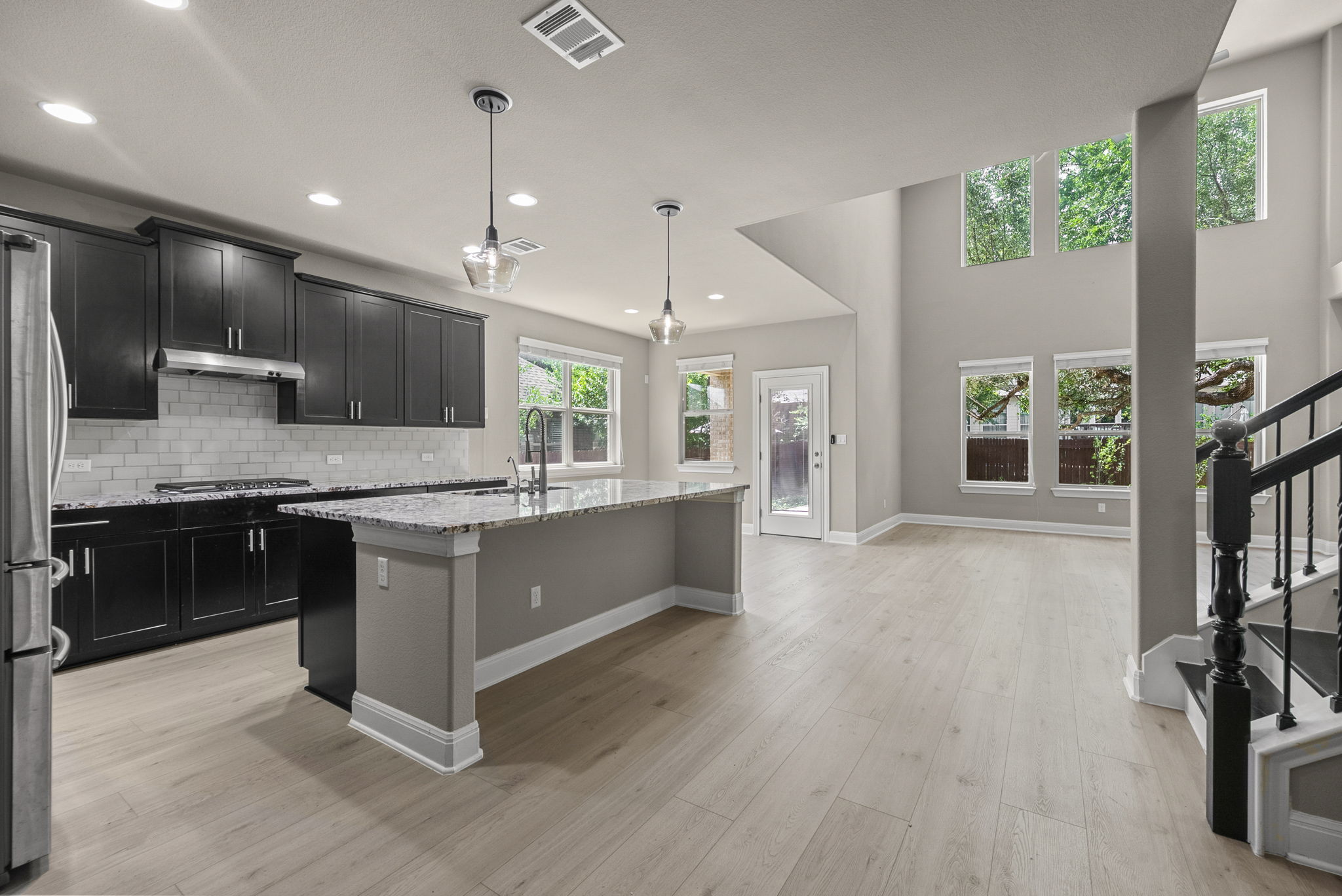 4401 Trinity Woods Street Leander, TX 78641 - Photo 14 of 37 A grand, open-concept living space with high ceilings and a modern kitchen.