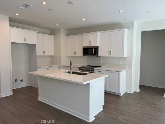 a kitchen with stainless steel appliances a sink stove and refrigerator