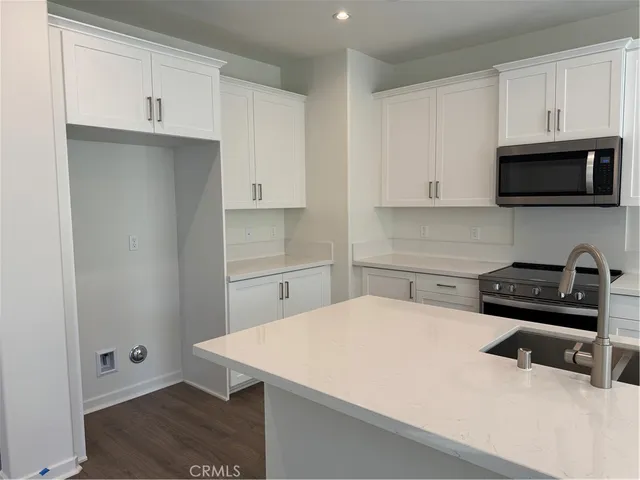 a kitchen with a sink a stove and cabinets