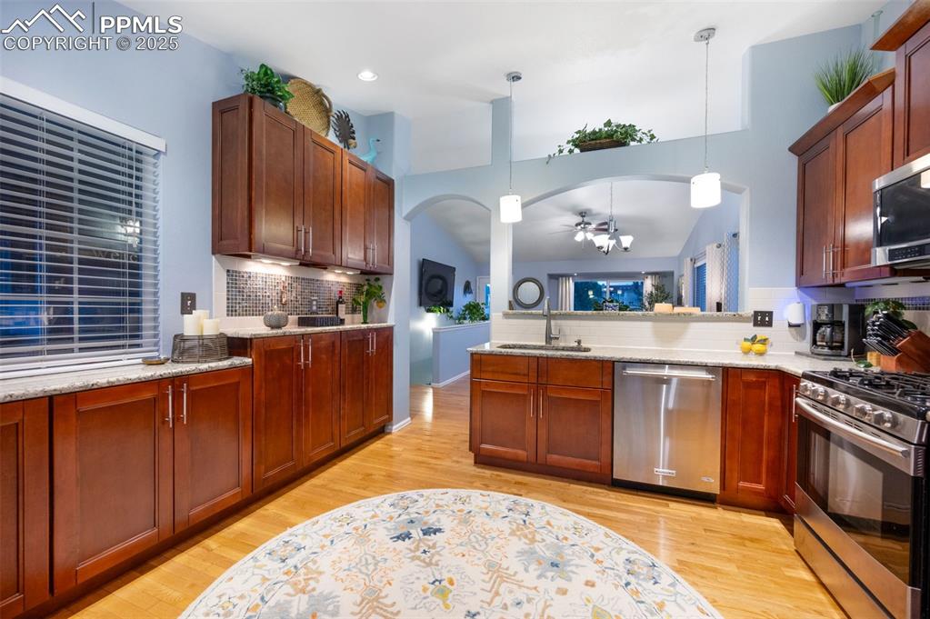 6370 Perfect View Colorado Springs, CO 80919 - Photo 11 of 49 a kitchen with stainless steel appliances granite countertop a stove a sink and a wooden cabinets