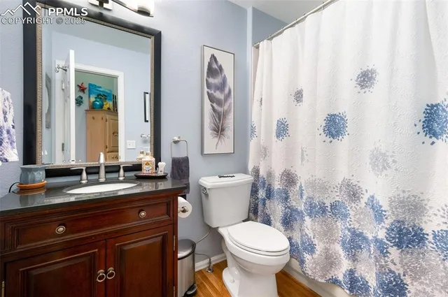 a bathroom with a granite countertop sink a toilet and a mirror