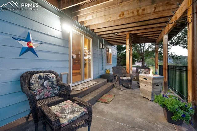 a view of a chairs and table in the patio next to a yard