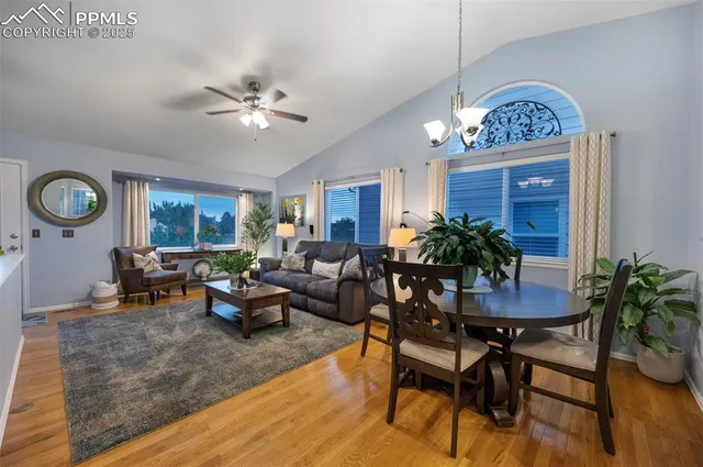 a living room with furniture a chandelier and a potted plant