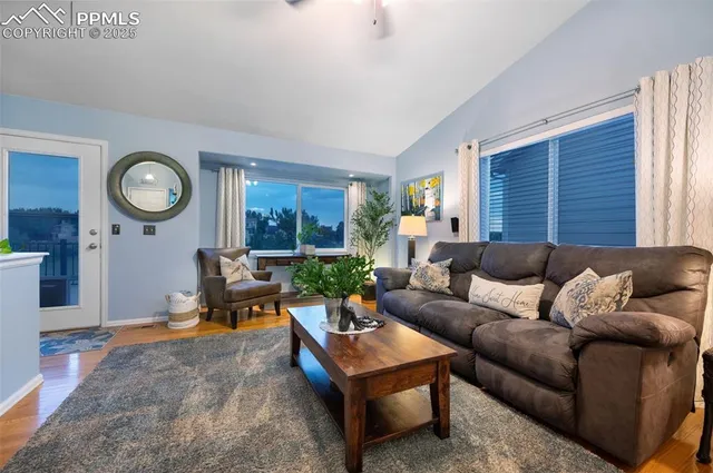 a living room with furniture a clock on wall and a window