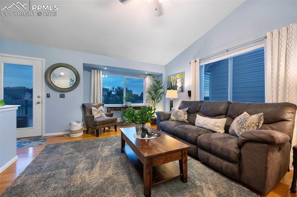 6370 Perfect View Colorado Springs, CO 80919 - Photo 7 of 49 a living room with furniture a clock on wall and a window