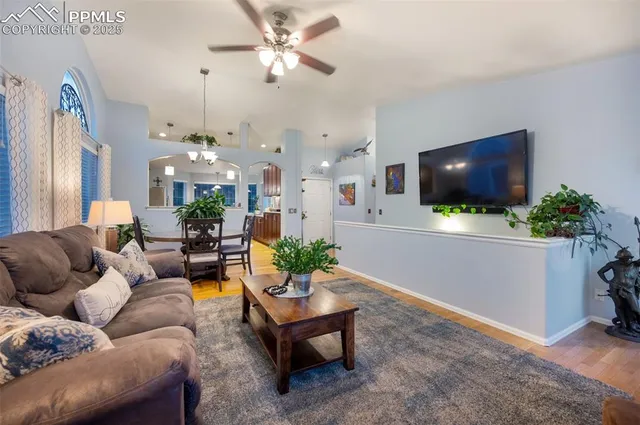 a living room with furniture a chandelier and a flat screen tv
