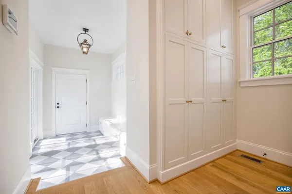 a view of a hallway with wooden floor and a bathroom