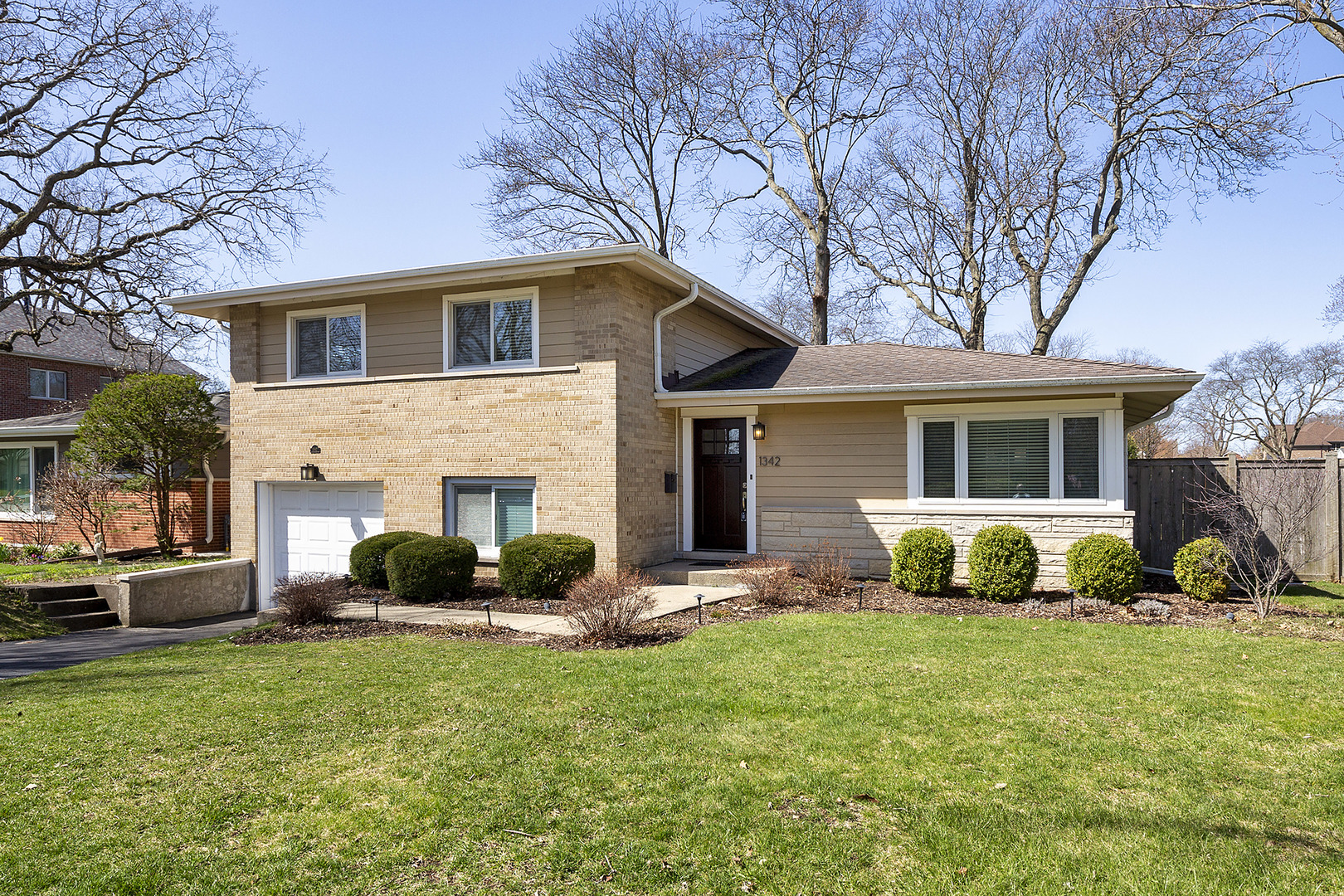 1342 Kenton Road Deerfield, IL 60015 - Photo 1 of 12 a front view of a house with a garden and patio