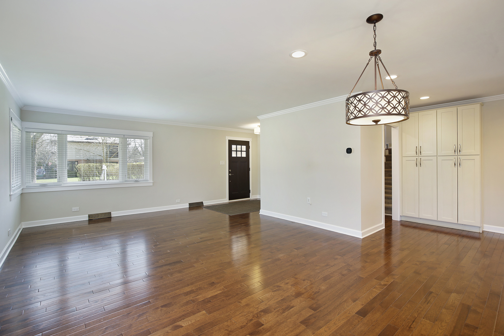 1342 Kenton Road Deerfield, IL 60015 - Photo 3 of 12 an empty room with wooden floor chandelier and windows