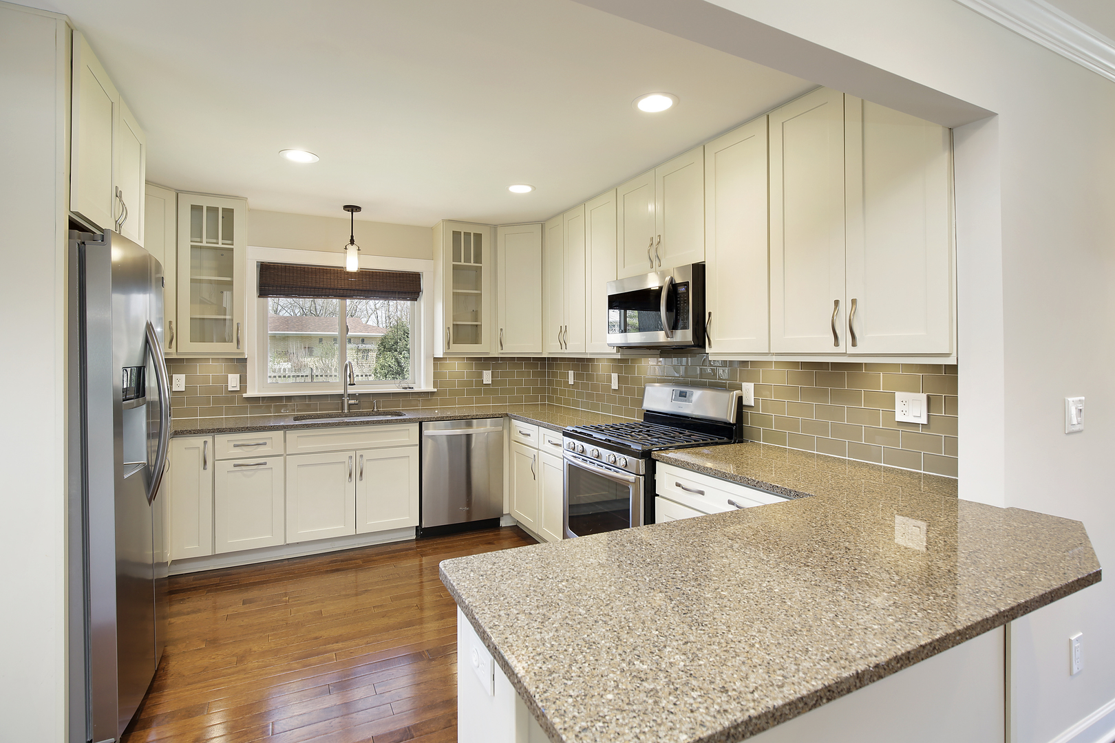 1342 Kenton Road Deerfield, IL 60015 - Photo 5 of 12 a kitchen with kitchen island granite countertop a sink counter top space appliances and cabinets