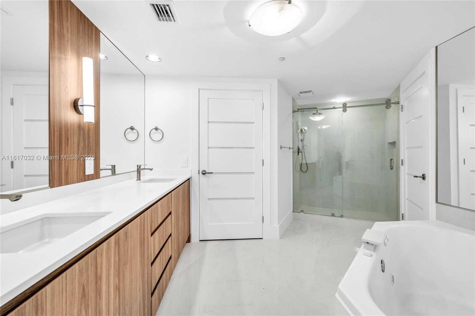 18911 Collins Avenue, Unit 1003 Sunny Isles Beach, FL 33160 - Photo 13 of 47 a bathroom with a tub sink mirror and shower