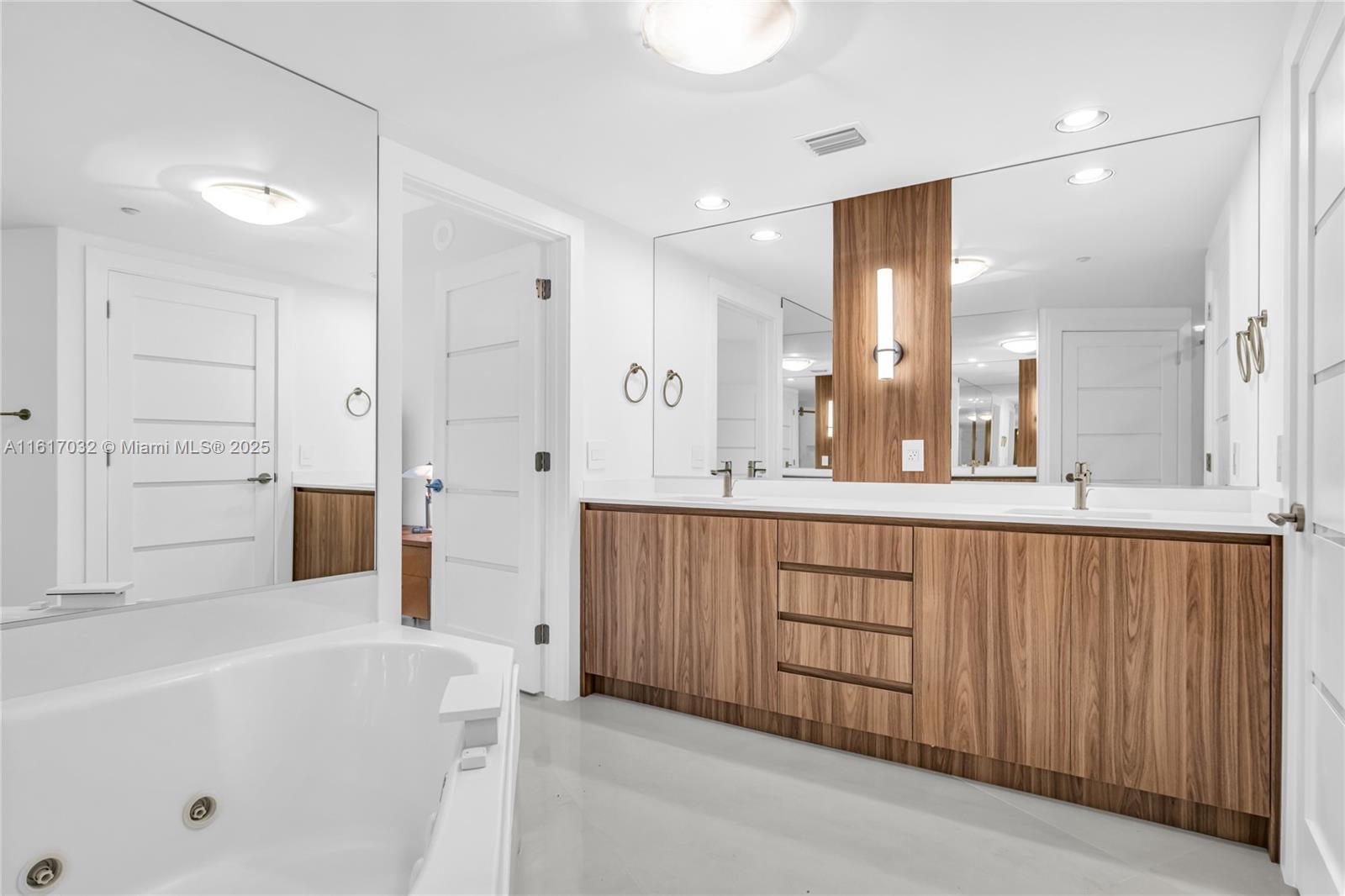 18911 Collins Avenue, Unit 1003 Sunny Isles Beach, FL 33160 - Photo 15 of 47 a bathroom with a tub a sink and mirrors