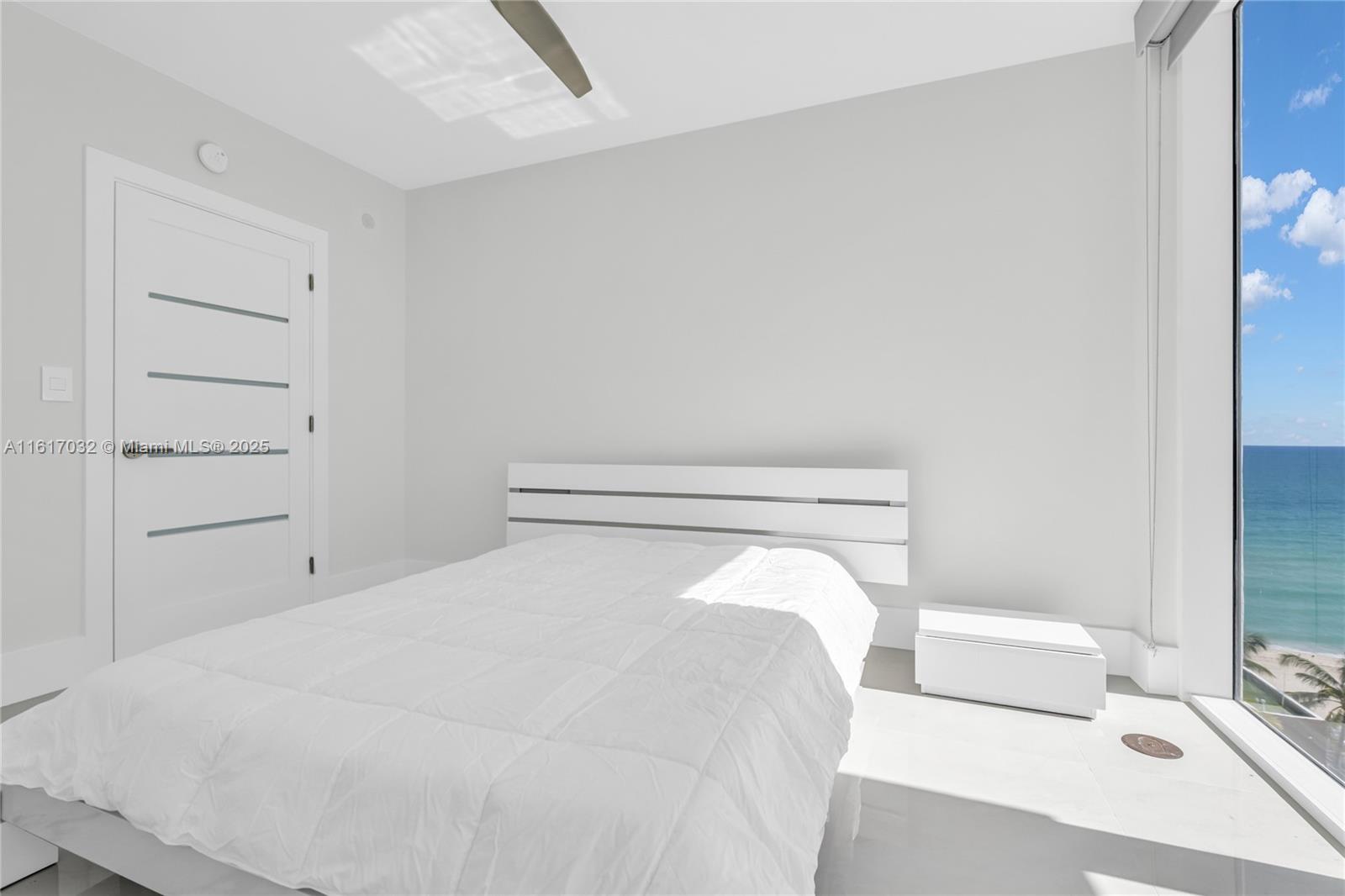 18911 Collins Avenue, Unit 1003 Sunny Isles Beach, FL 33160 - Photo 20 of 47 a bed room with a bed and a night stand