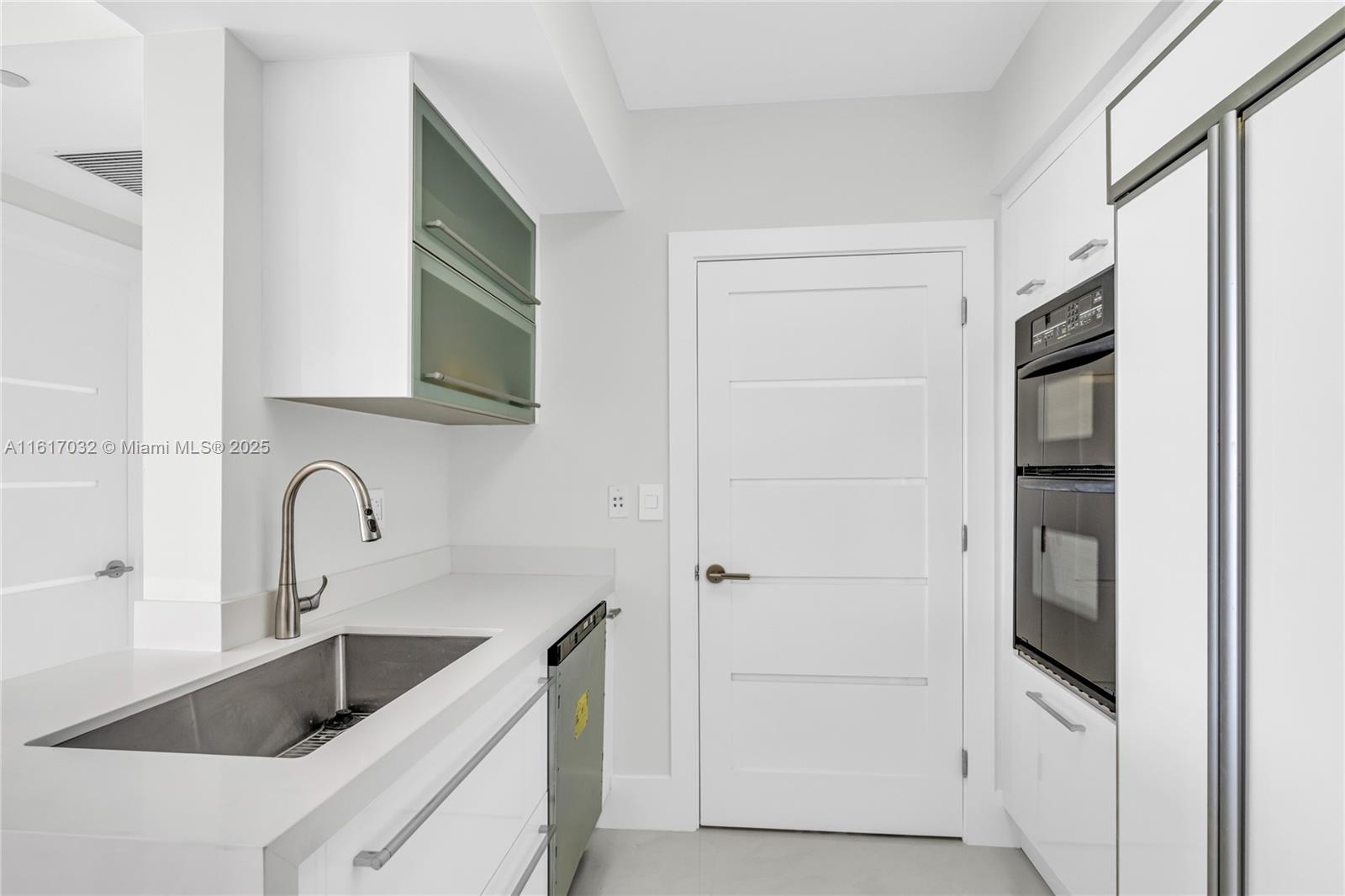 18911 Collins Avenue, Unit 1003 Sunny Isles Beach, FL 33160 - Photo 2 of 47 a kitchen with a refrigerator and a sink