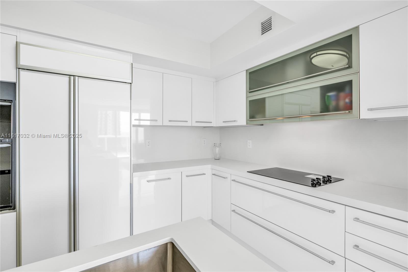 18911 Collins Avenue, Unit 1003 Sunny Isles Beach, FL 33160 - Photo 3 of 47 a kitchen with white cabinets and white appliances
