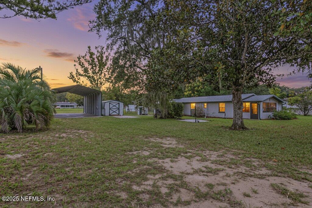 24480 Northeast 127 Street Salt Springs, FL 32134 - Photo 1 of 59 a view of a yard in front of a house with a large tree