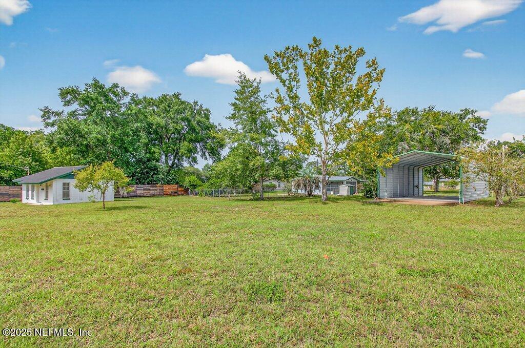24480 Northeast 127 Street Salt Springs, FL 32134 - Photo 2 of 59 a front view of a house with a garden and trees