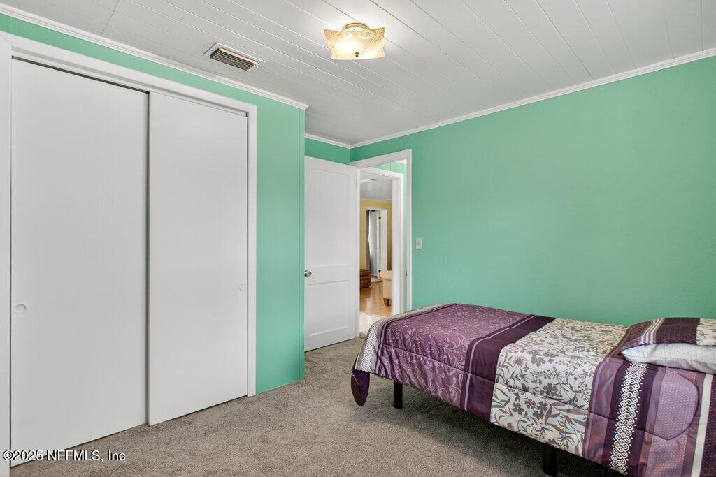 24480 Northeast 127 Street Salt Springs, FL 32134 - Photo 30 of 59 a bedroom with a bed and a chandelier