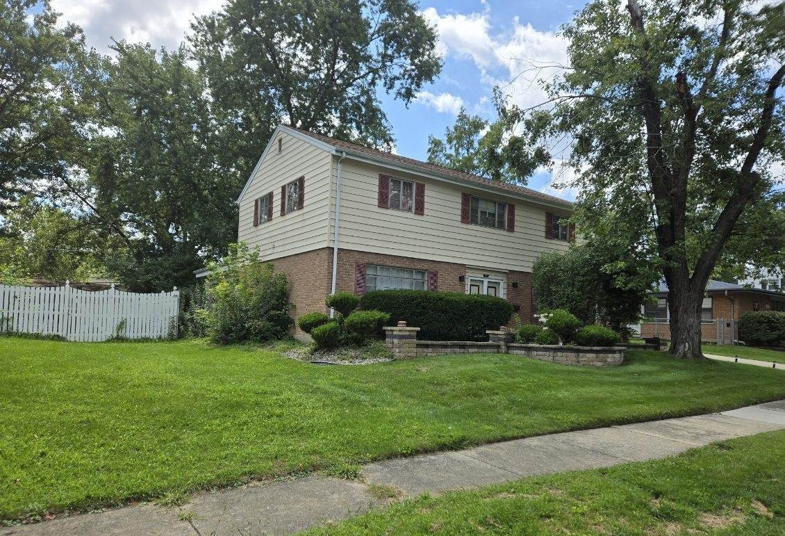 a front view of a house with a yard and trees