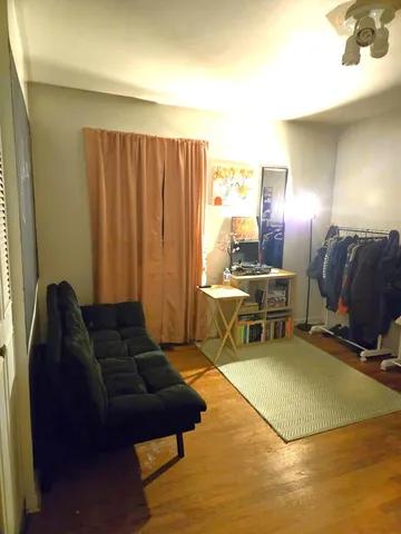 a living room with furniture a dining table and chairs with wooden floor