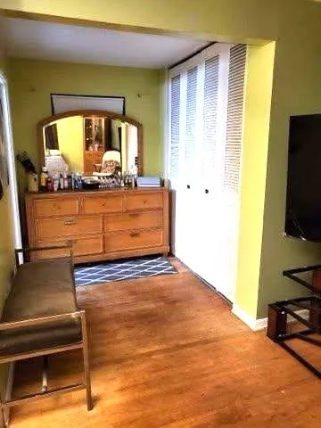 a bedroom with a bed and a flat tv screen on dresser