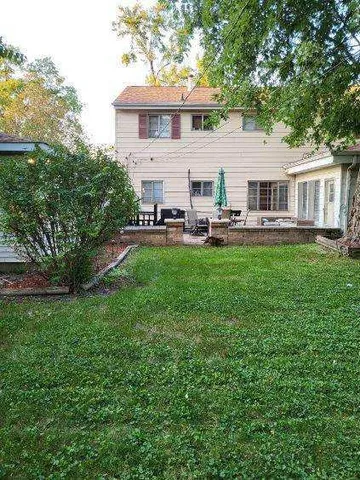a view of a house with backyard sitting area and garden
