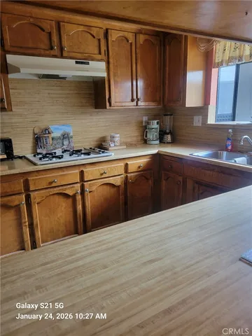 a kitchen with stainless steel appliances granite countertop a sink dishwasher a stove and cabinets with wooden floor