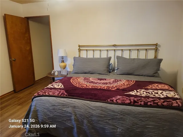 a bedroom with a bed and wooden floor