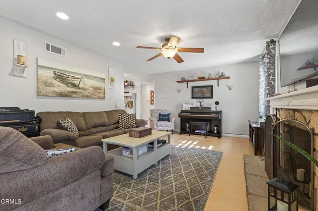 a living room with furniture a fireplace and a flat screen tv