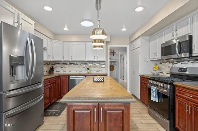 a kitchen with stainless steel appliances a stove sink microwave and cabinets
