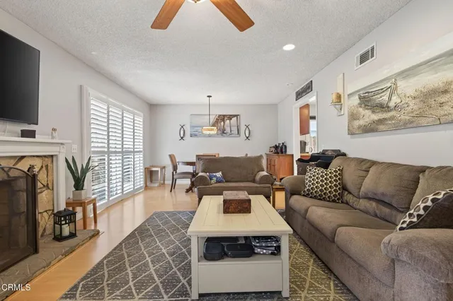 a living room with furniture a flat screen tv and a fireplace